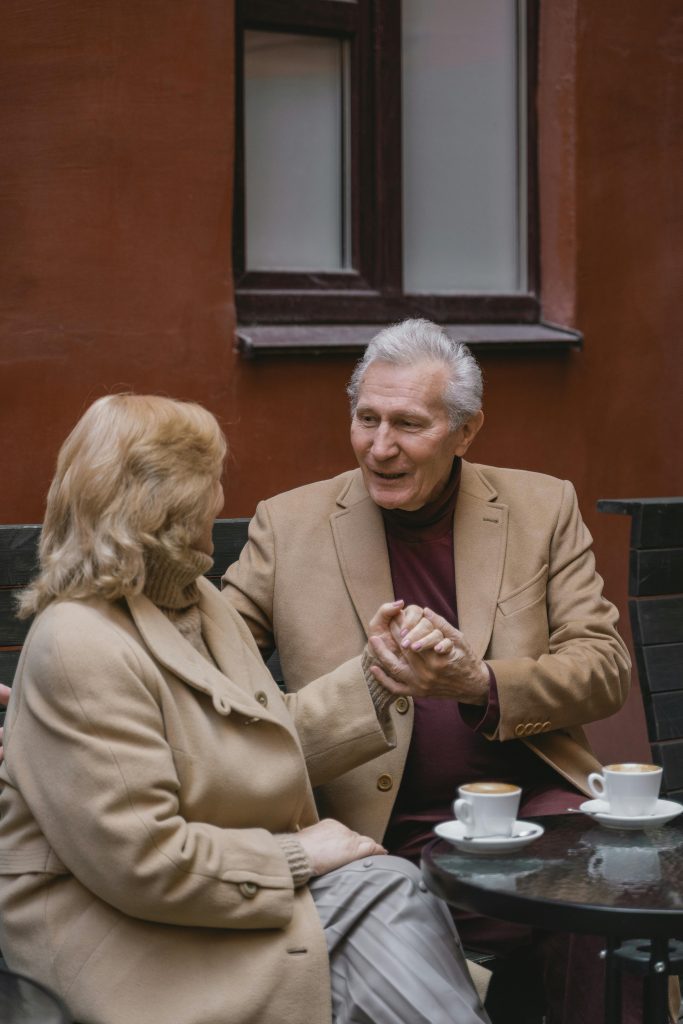 two elderly people in love in a romantic bar holding hands